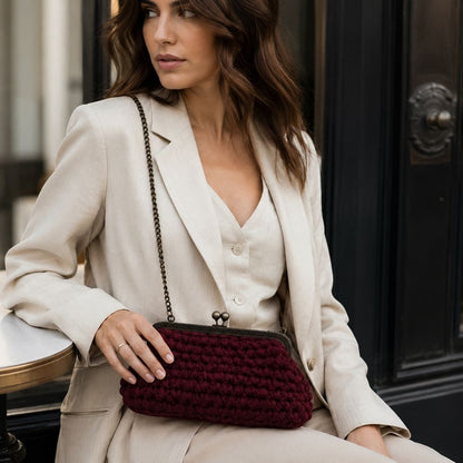 Borsa Granato bordeaux indossata a spalla con tracolla a catena in look elegante